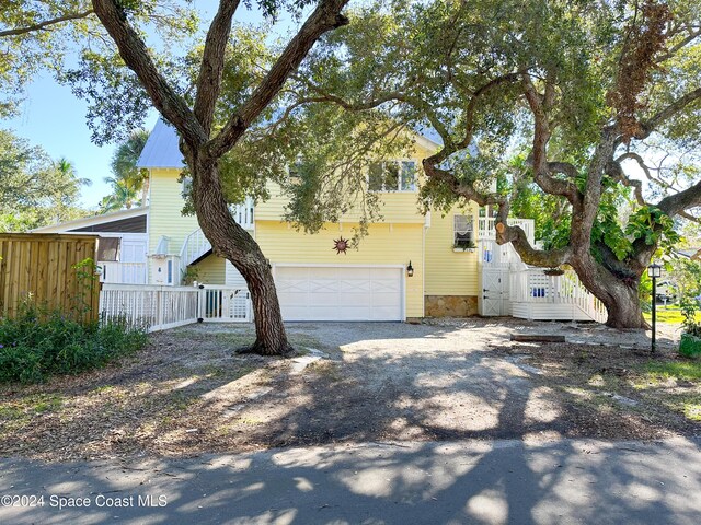 5875 Riverside Dr, Melbourne Beach, FL 32951 - view of front facade with a garage and driveway