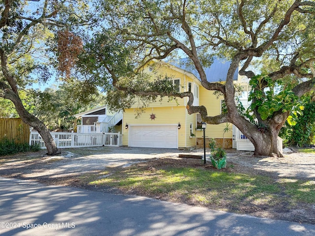 5875 Riverside Dr, Melbourne Beach, FL 32951 - view of front facade featuring dirt driveway and an attached garage
