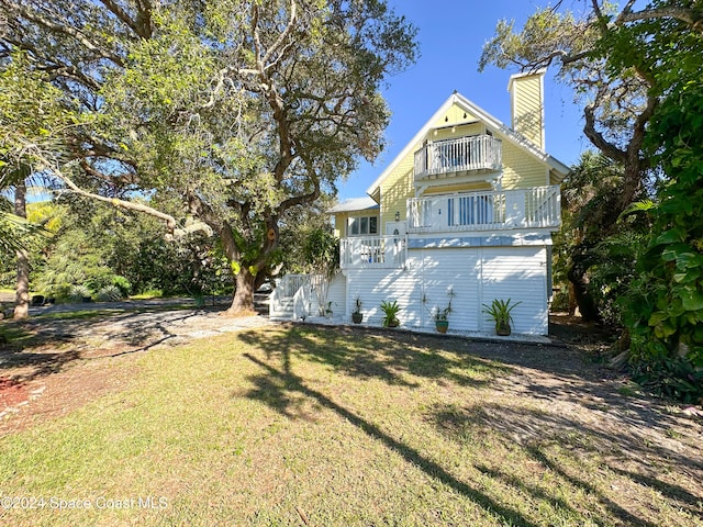 exterior space with a balcony and a front yard