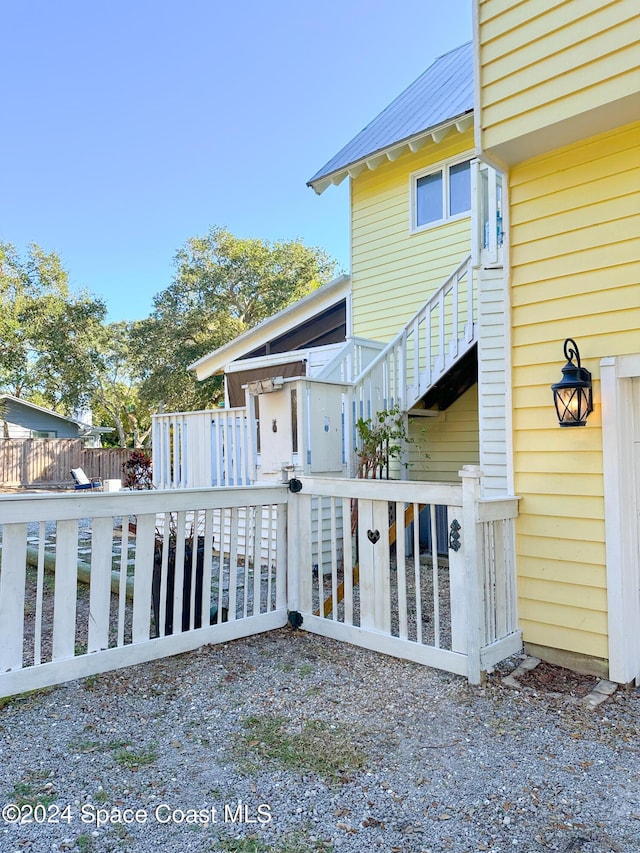 5875 Riverside Dr, Melbourne Beach, FL 32951 - rear view of property with metal roof and a wooden deck