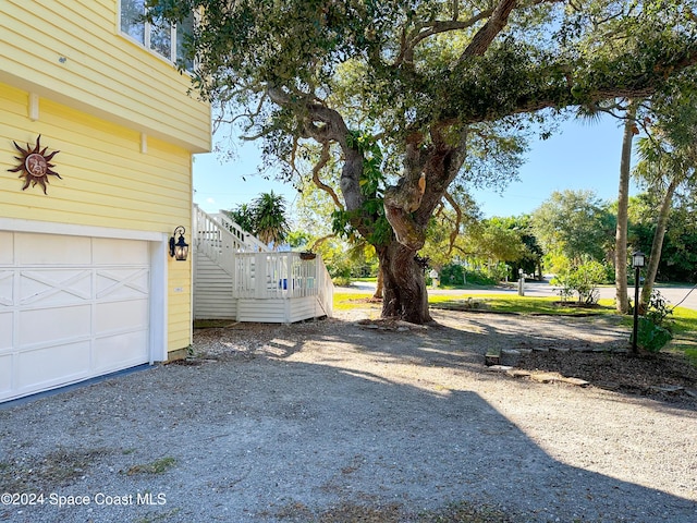 5875 Riverside Dr, Melbourne Beach, FL 32951 - view of yard featuring a garage and stairs