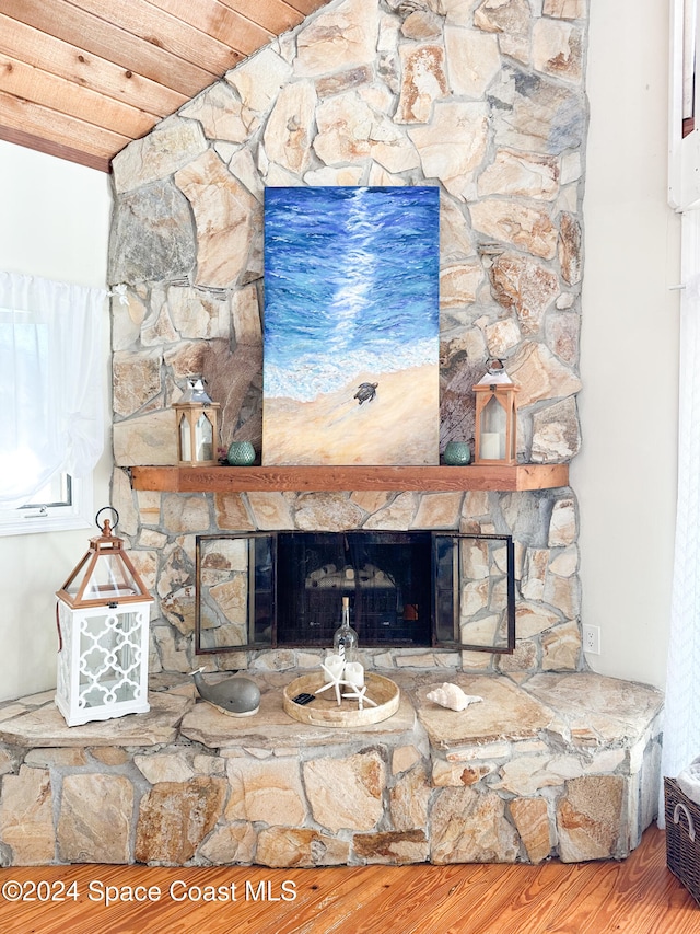 details with hardwood / wood-style floors, a stone fireplace, and wood ceiling