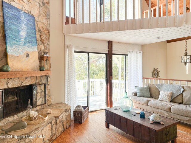 living room with light hardwood / wood-style floors and a stone fireplace