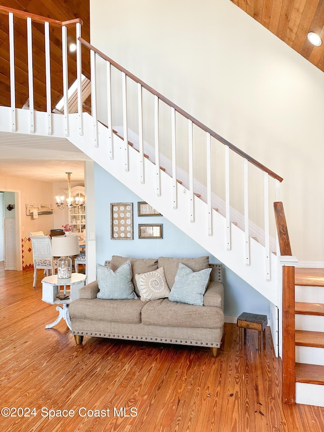 5875 Riverside Dr, Melbourne Beach, FL 32951 - living area with stairs, high vaulted ceiling, wood finished floors, and a chandelier