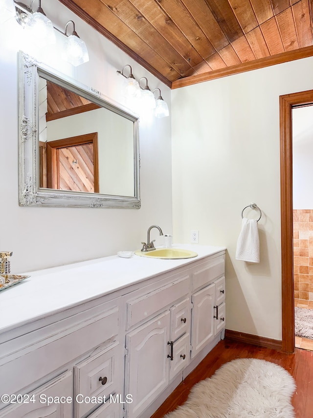 bathroom featuring hardwood / wood-style flooring, vanity, wood ceiling, and ornamental molding