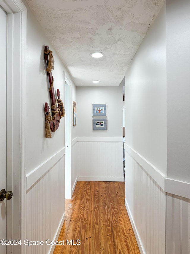 5875 Riverside Dr, Melbourne Beach, FL 32951 - hallway featuring light wood-style flooring and wainscoting