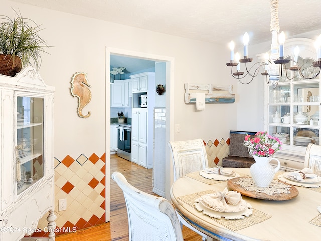 dining space with an inviting chandelier and light hardwood / wood-style flooring