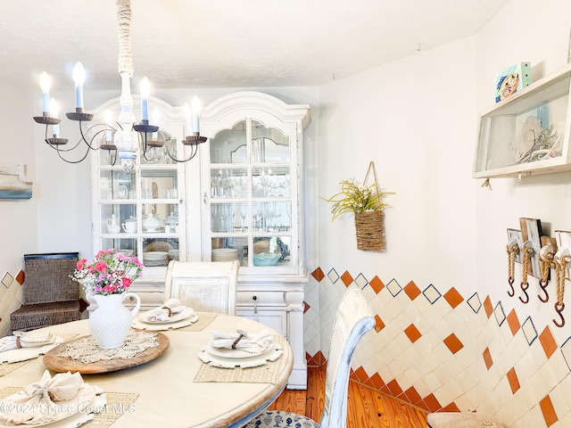 dining room with hardwood / wood-style floors and an inviting chandelier