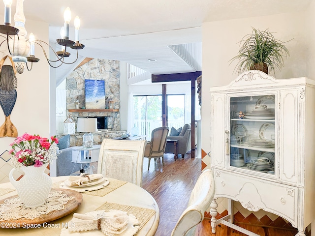 dining room featuring wood-type flooring and a stone fireplace