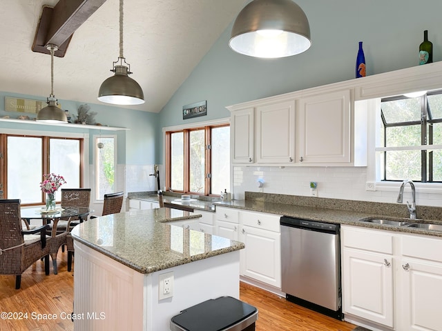 5875 Riverside Dr, Melbourne Beach, FL 32951 - kitchen with dishwasher, a sink, light wood-style floors, a center island, and high vaulted ceiling