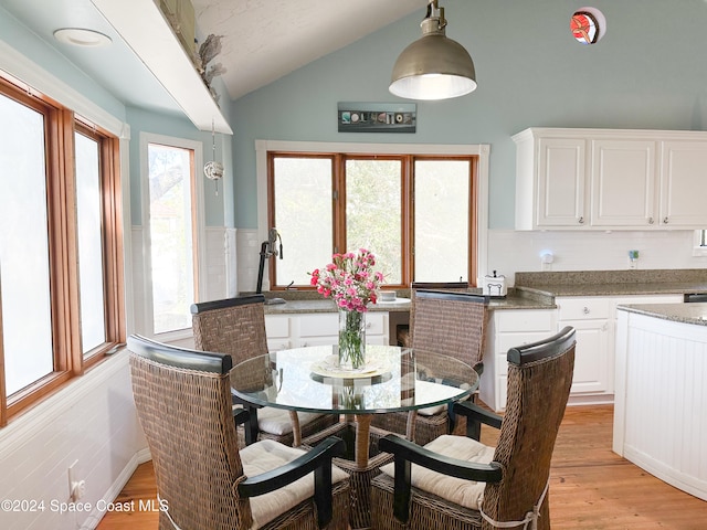 dining area featuring sink, vaulted ceiling, and light wood-type flooring