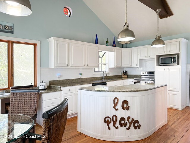 kitchen featuring appliances with stainless steel finishes, light wood-type flooring, pendant lighting, high vaulted ceiling, and white cabinetry