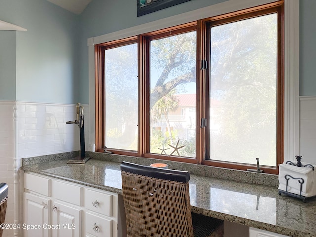 kitchen featuring light stone counters and white cabinets