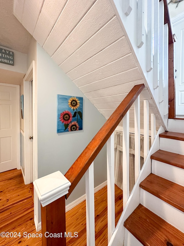 stairway with hardwood / wood-style flooring