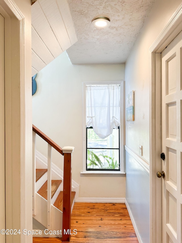 stairway featuring hardwood / wood-style floors and a textured ceiling