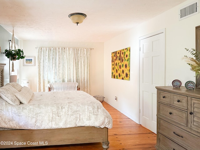 bedroom with light wood-type flooring and multiple windows