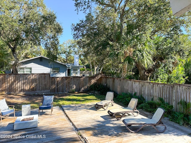 5875 Riverside Dr, Melbourne Beach, FL 32951 - fenced backyard with a wooden deck and an outdoor fire pit
