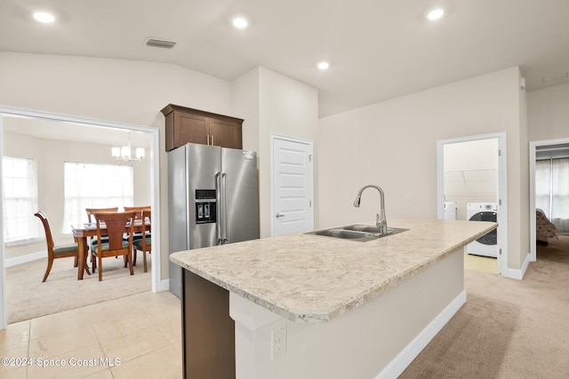 kitchen with sink, a kitchen island with sink, and light carpet