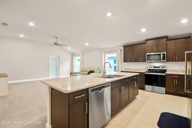 kitchen with ceiling fan, sink, an island with sink, vaulted ceiling, and appliances with stainless steel finishes