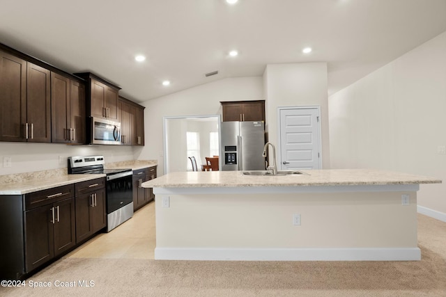 kitchen with stainless steel appliances, vaulted ceiling, a kitchen island with sink, and sink