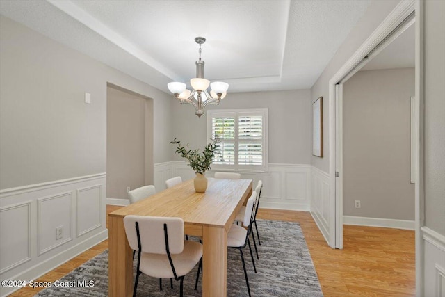 dining room with light hardwood / wood-style flooring and a notable chandelier