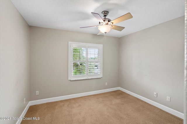 empty room featuring light colored carpet and ceiling fan