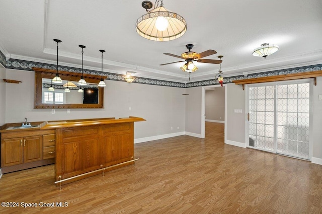 kitchen with plenty of natural light, ornamental molding, and light hardwood / wood-style flooring