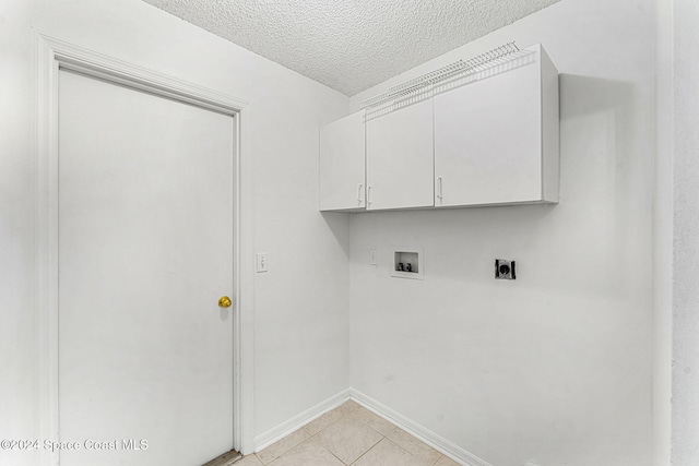 washroom with electric dryer hookup, cabinets, washer hookup, and a textured ceiling