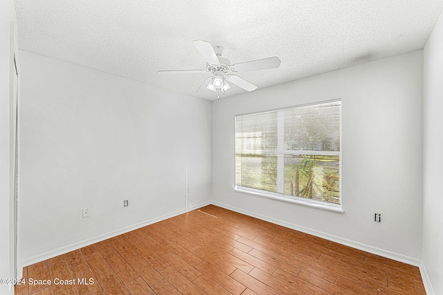 unfurnished room featuring hardwood / wood-style flooring, ceiling fan, and a textured ceiling