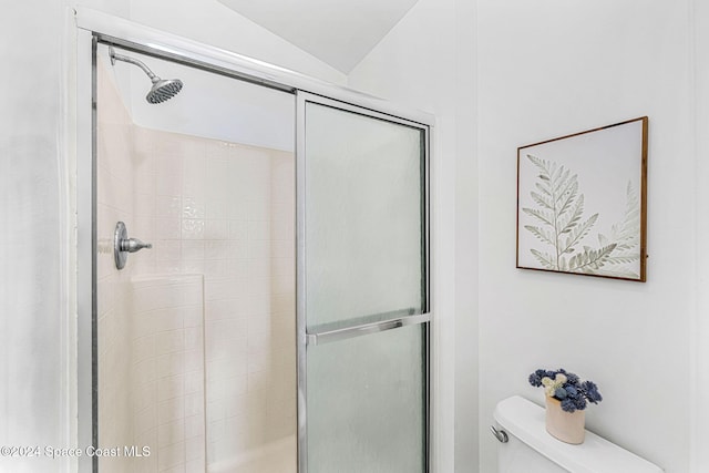 bathroom featuring walk in shower, vaulted ceiling, and toilet