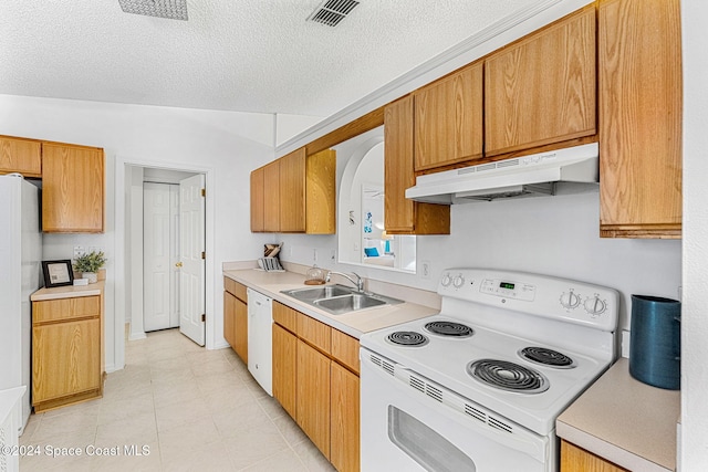 kitchen featuring a textured ceiling, white appliances, lofted ceiling, and sink