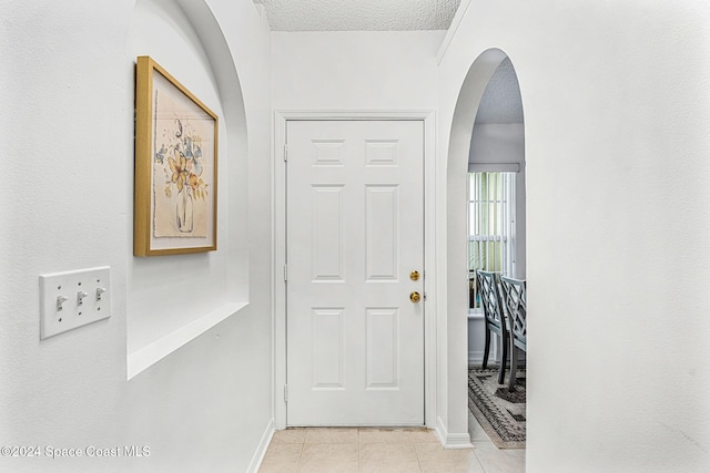 tiled entryway with a textured ceiling