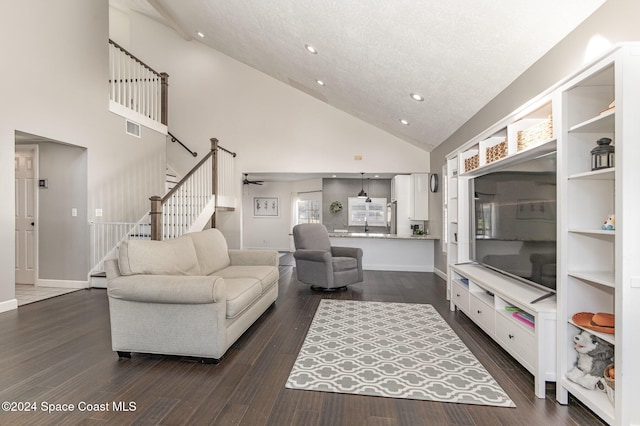 living room featuring a textured ceiling, high vaulted ceiling, ceiling fan, and dark wood-type flooring