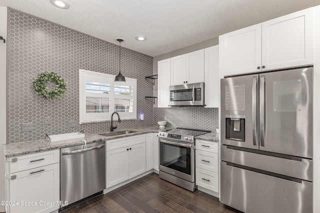 kitchen featuring white cabinets, stainless steel appliances, and hanging light fixtures