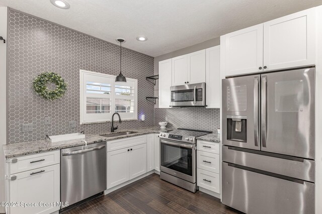 1010 Citrus Ave NE, Palm Bay, FL 32905 - kitchen with stainless steel appliances, white cabinets, backsplash, light stone counters, and recessed lighting