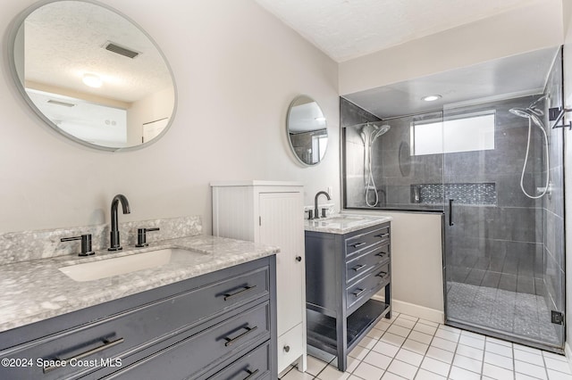 1010 Citrus Ave NE, Palm Bay, FL 32905 - bathroom featuring a shower stall, tile patterned flooring, two vanities, and a textured ceiling