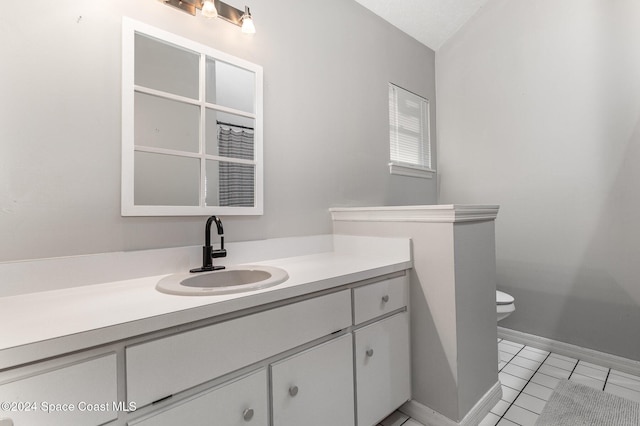 bathroom with tile patterned flooring, vanity, and toilet