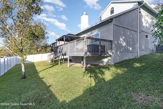 rear view of property with a yard and a wooden deck