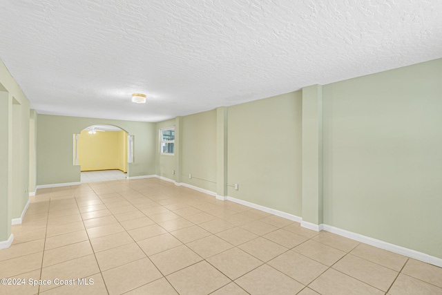 tiled empty room with a textured ceiling