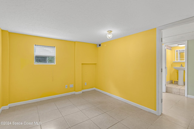 spare room featuring tile patterned floors and a textured ceiling