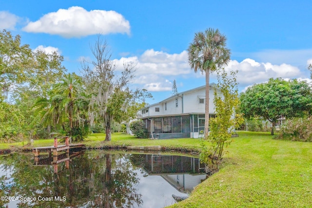 back of property with a lawn and a sunroom