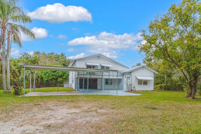 back of house with a carport and a yard