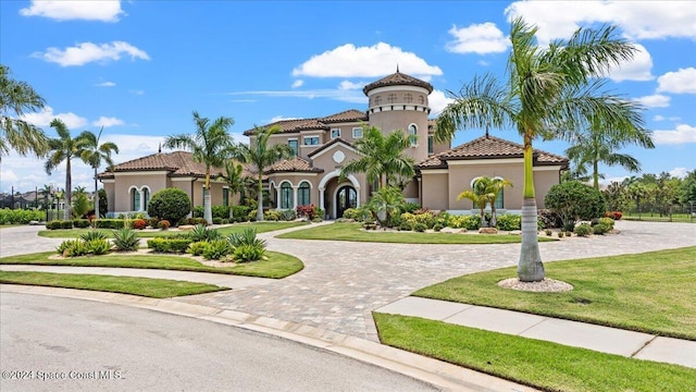 4695 Tea Tree Ct, Rockledge, FL 32955 - mediterranean / spanish home with stucco siding, curved driveway, a tile roof, and a front yard