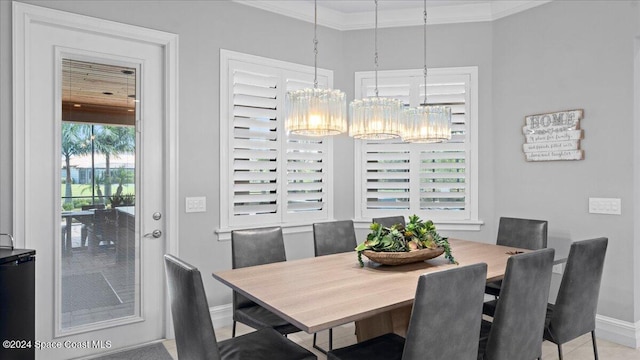 dining area with ornamental molding and a chandelier