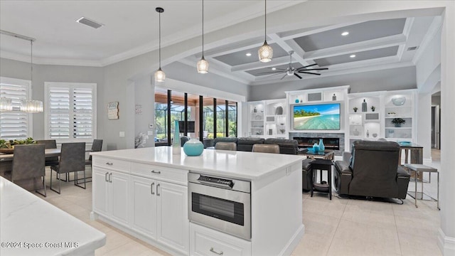 kitchen featuring stainless steel oven, coffered ceiling, white cabinets, hanging light fixtures, and ceiling fan