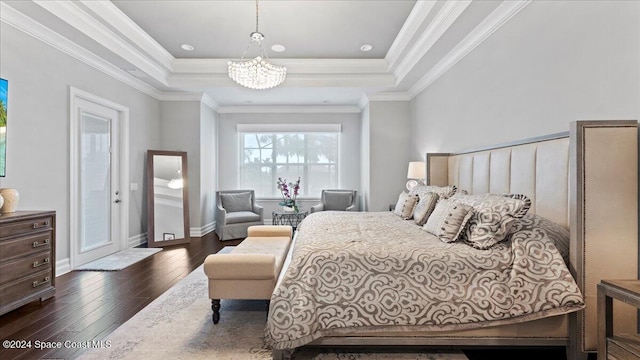 bedroom with a notable chandelier, dark hardwood / wood-style floors, ornamental molding, and a tray ceiling