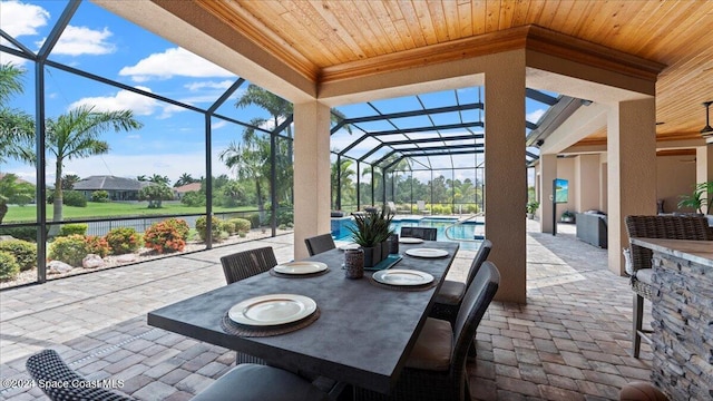 view of patio featuring glass enclosure