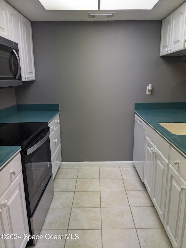 kitchen with white cabinets, stainless steel appliances, and light tile patterned floors