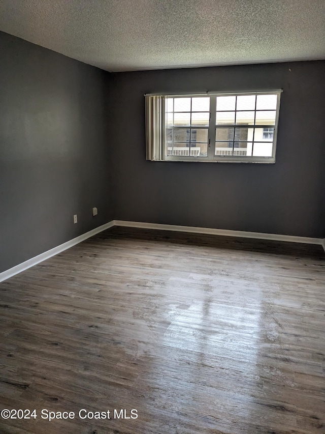 unfurnished room featuring hardwood / wood-style floors, a healthy amount of sunlight, and a textured ceiling