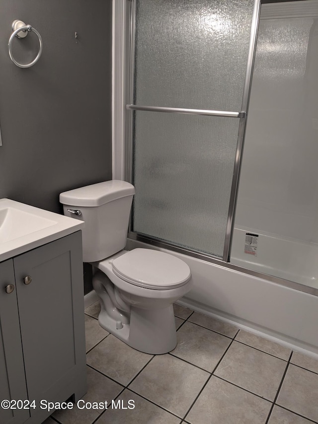 full bathroom featuring tile patterned flooring, vanity, toilet, and bath / shower combo with glass door